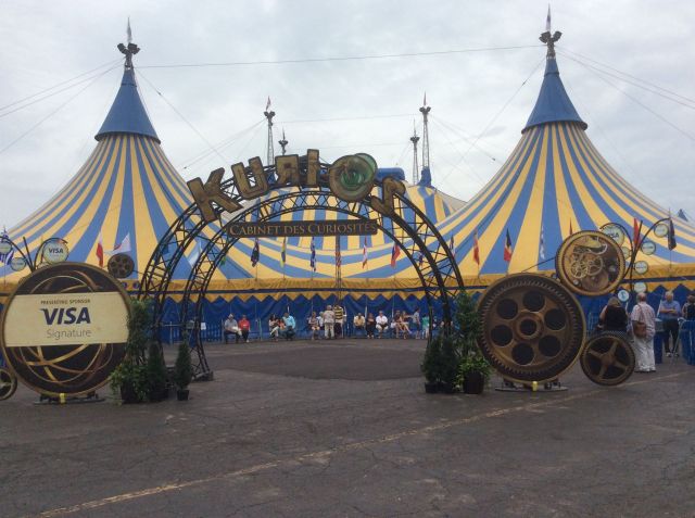 Cirque tent: large multi-post tent made of bold yellow and blue stripes with a decorative arc entrance